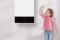 The picture shows a little girl next to a Viessmann wall mounted gas condensing boiler.